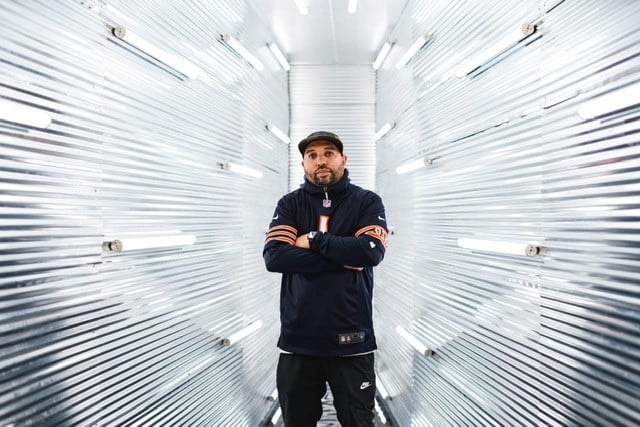 Photo of DJ Jay iLLa in front of a silver background.